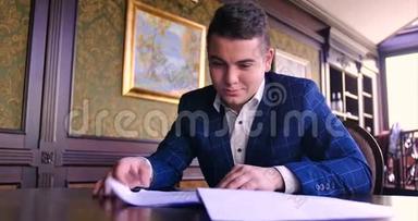 一个年轻的商人坐在别致的办公室里，对一份纸合同感到不满，拒绝<strong>签字</strong>，生气，不愿<strong>签字</strong>